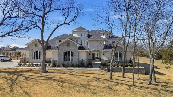 a front view of a building with large trees