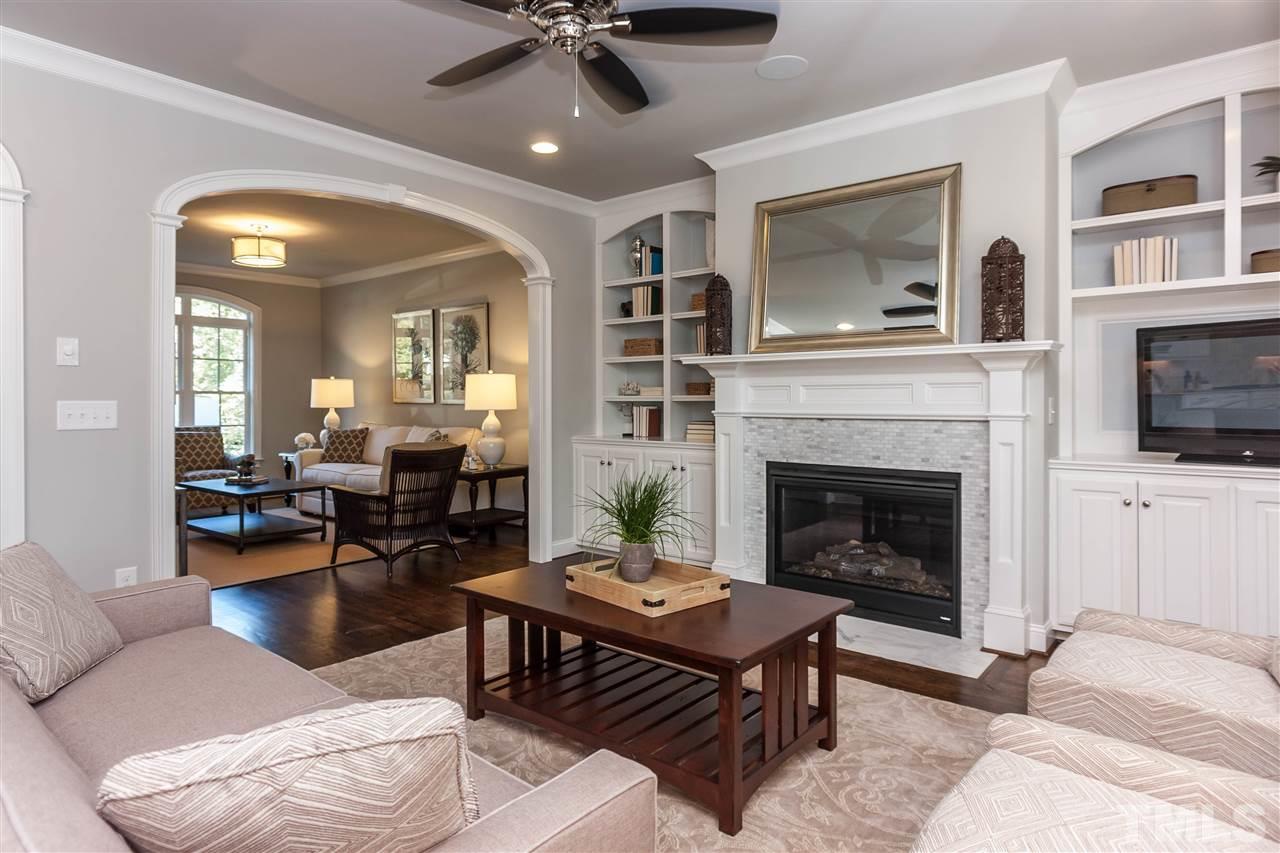 3106 Ashel Street Raleigh, NC 27612 - Photo 7 of 25 a living room with furniture a flat screen tv and a fireplace
