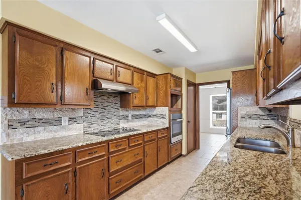a kitchen with stainless steel appliances granite countertop a sink stove and cabinets