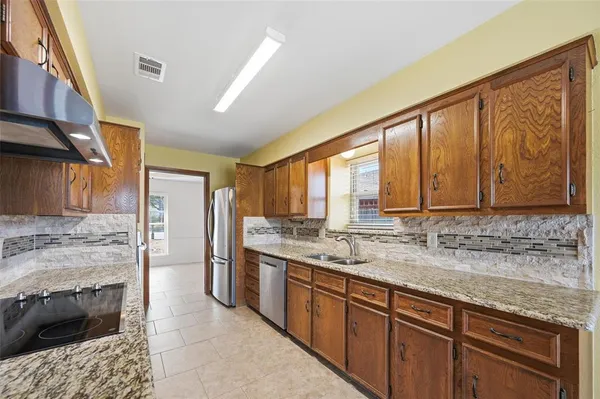 a kitchen with stainless steel appliances granite countertop a sink stove and cabinets