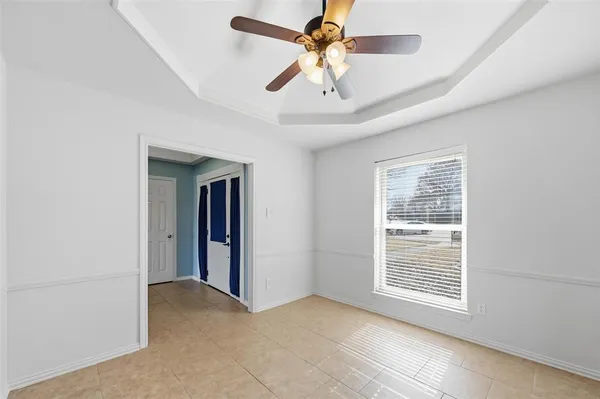 a view of an empty room with chandelier and fireplace