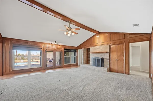 a view of an empty room with a fireplace and a window