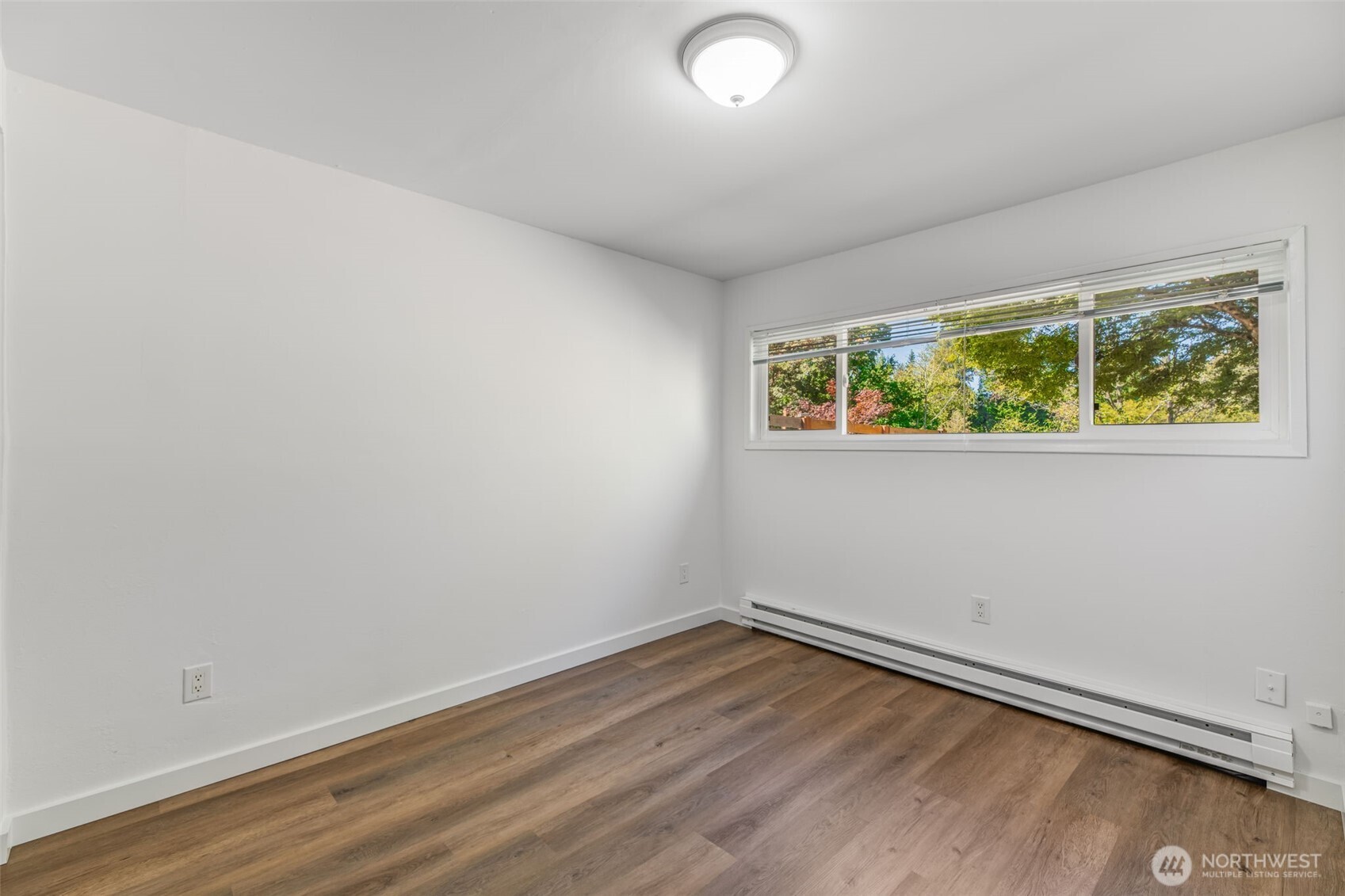 7051 South 125th Street Seattle, WA 98178 - Photo 17 of 32 an empty room with wooden floor and windows