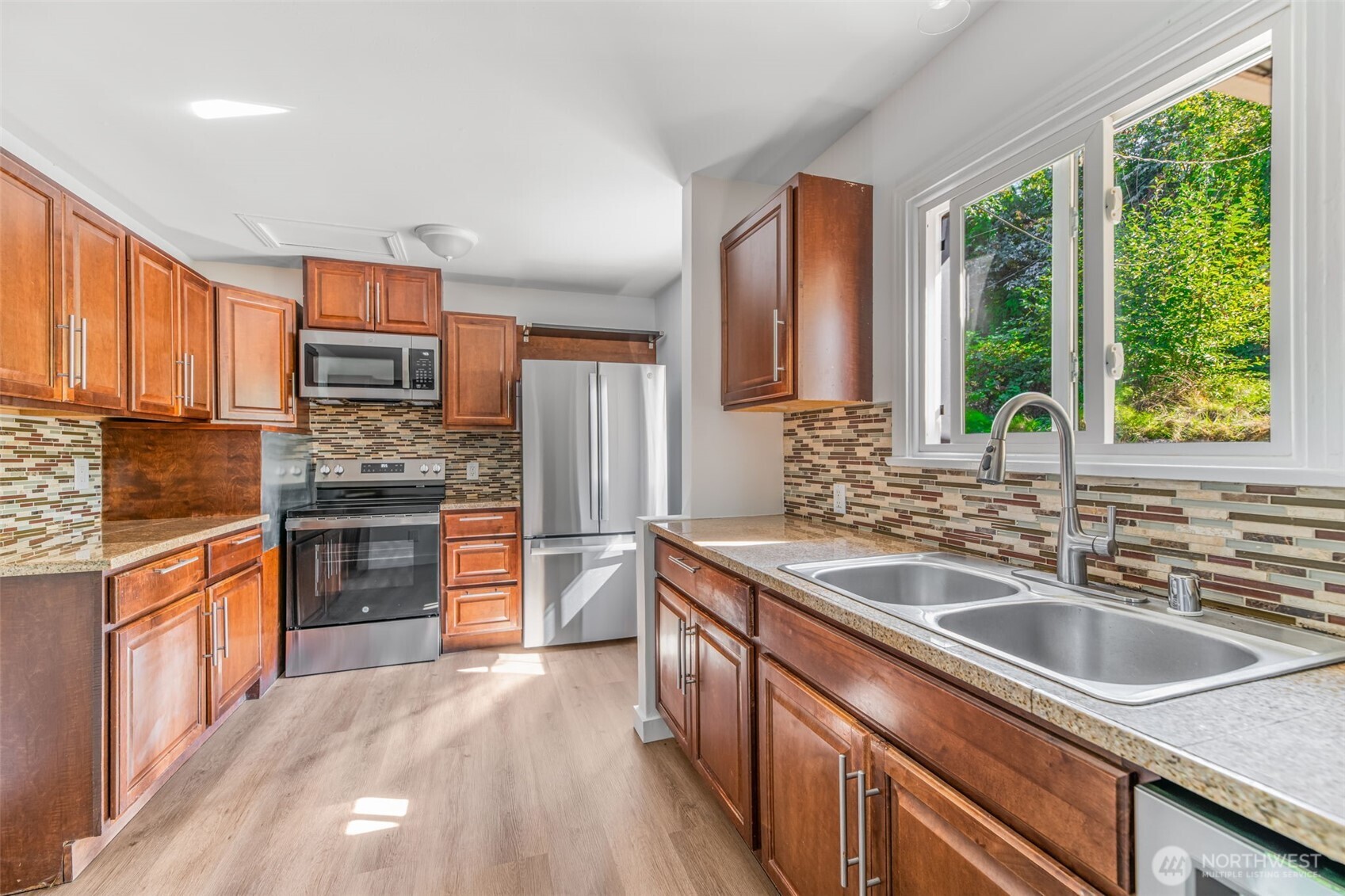 7051 South 125th Street Seattle, WA 98178 - Photo 4 of 32 a kitchen with stainless steel appliances granite countertop a sink stove and refrigerator