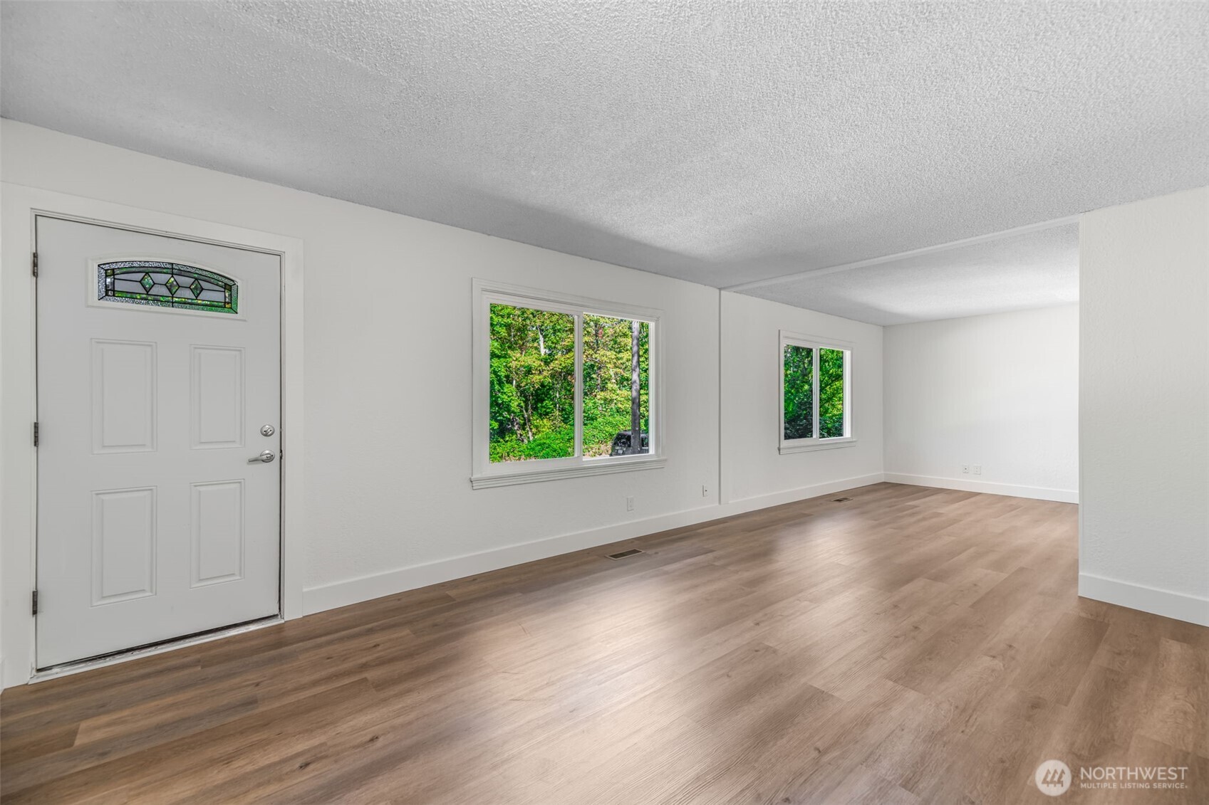 7051 South 125th Street Seattle, WA 98178 - Photo 8 of 32 an empty room with wooden floor and windows