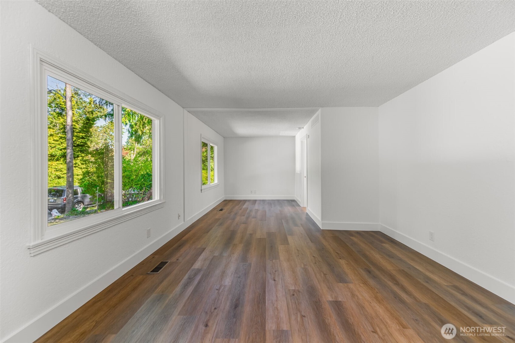 7051 South 125th Street Seattle, WA 98178 - Photo 9 of 32 a view of empty room with wooden floor and fan