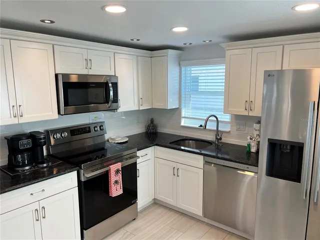 a kitchen with a sink stove and microwave