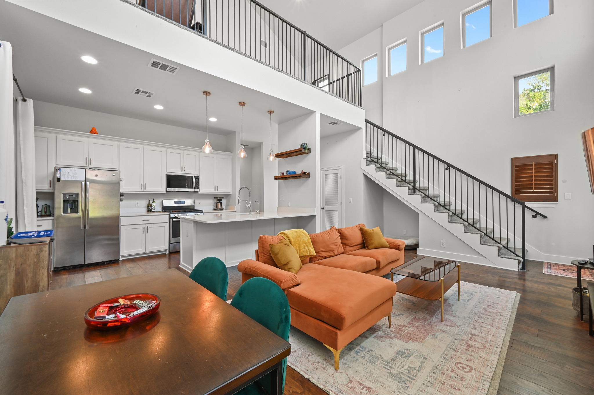 592 Farm To Market 967, Unit B Buda, TX 78610 - Photo 12 of 26 Architectural details take center stage with the dramatic staircase and soaring two-story ceilings, adding character and enhancing the home's bright, open feel.