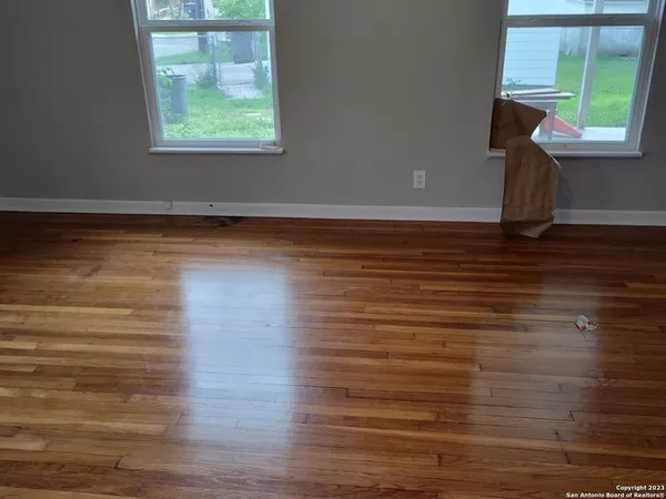 a view of an empty room with wooden floor