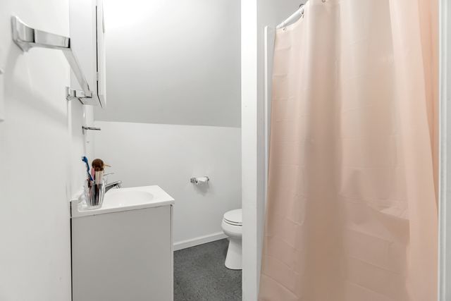 a bathroom with a sink a toilet and shower curtain