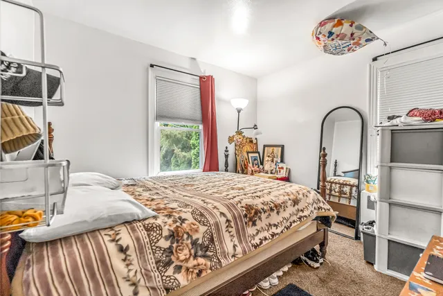 a bedroom with a bed and dresser with window