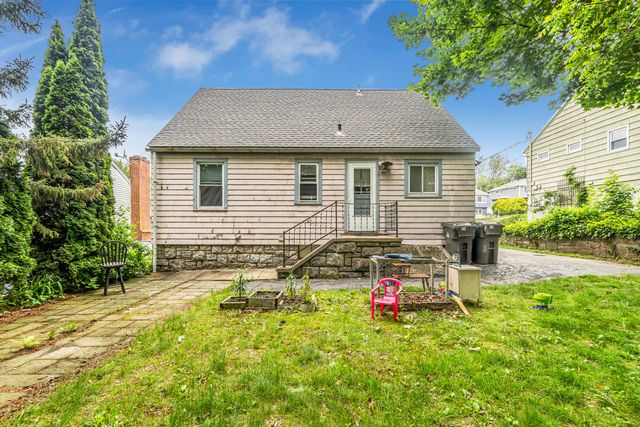 a backyard of a house with table and chairs and potted plants