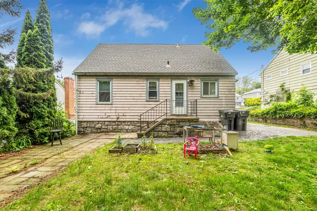 a backyard of a house with table and chairs and potted plants
