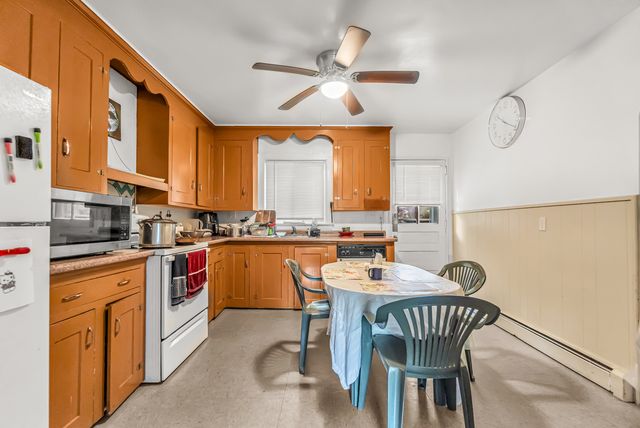 a kitchen with stainless steel appliances granite countertop a stove a sink dishwasher and a refrigerator with wooden floor