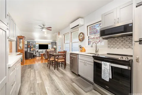 a kitchen with stainless steel appliances a stove a sink dishwasher and a refrigerator with wooden floor