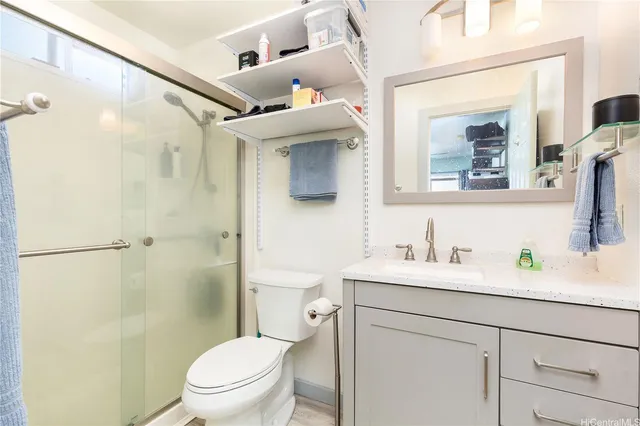 a bathroom with a granite countertop sink mirror vanity and toilet