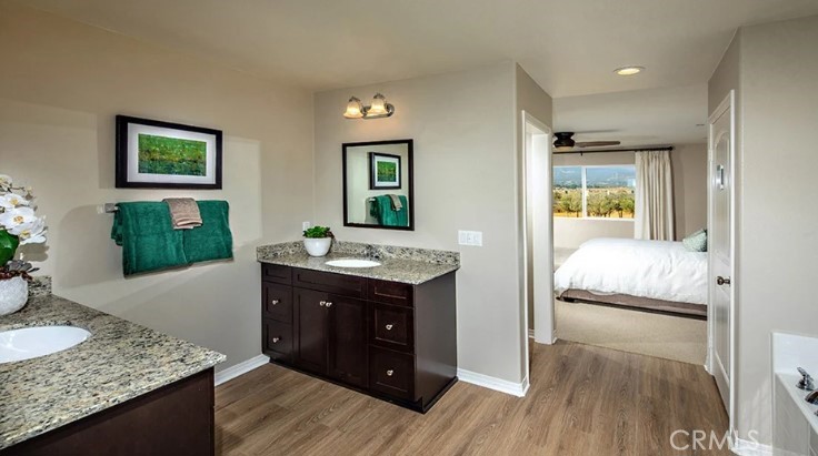 14073 Versimo Lane Beaumont, CA 92223 - Photo 12 of 20 a en suite bathroom with a granite countertop sink and a mirror