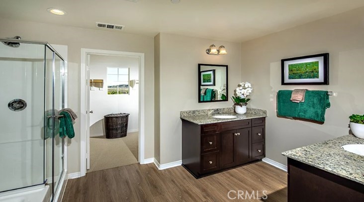 14073 Versimo Lane Beaumont, CA 92223 - Photo 13 of 20 a spacious bathroom with a granite countertop sink a mirror and shower