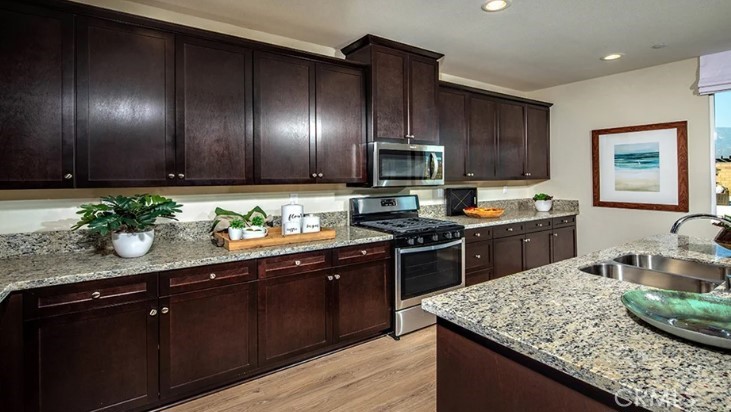 14073 Versimo Lane Beaumont, CA 92223 - Photo 10 of 20 a kitchen with kitchen island granite countertop stainless steel appliances stove microwave and sink