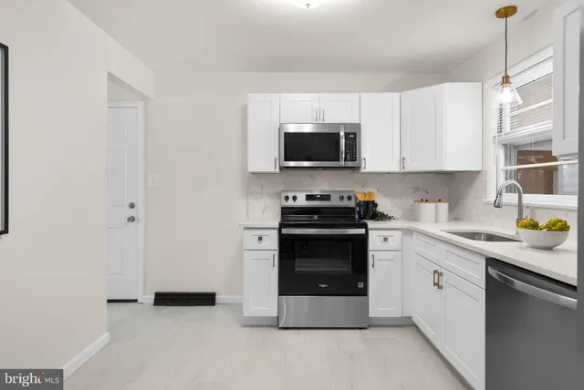 a kitchen with stainless steel appliances a stove microwave and sink