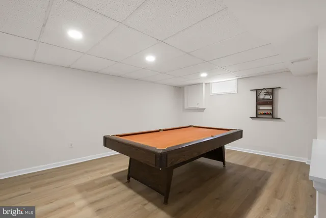 a room with wooden floor and pool table