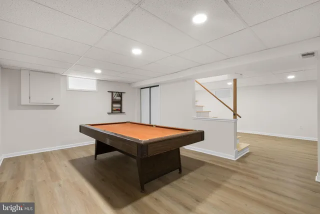 a room with wooden floor and pool table
