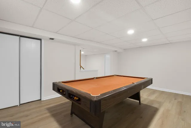 a room with pool table and wooden floor