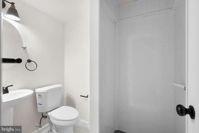 a white toilet sitting next to a shower