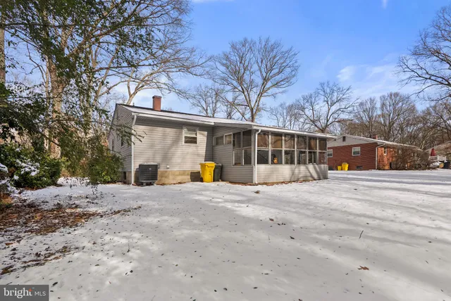 a front view of a house with a dirt yard and a large tree
