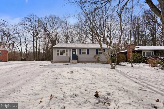a front view of a house with a yard covered with snow in front of house