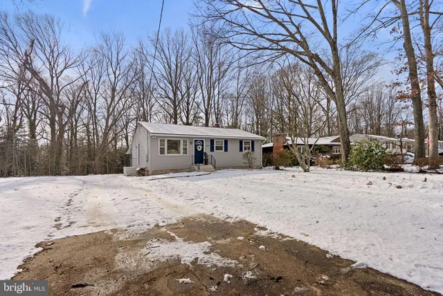 a front view of a house with a yard covered in snow