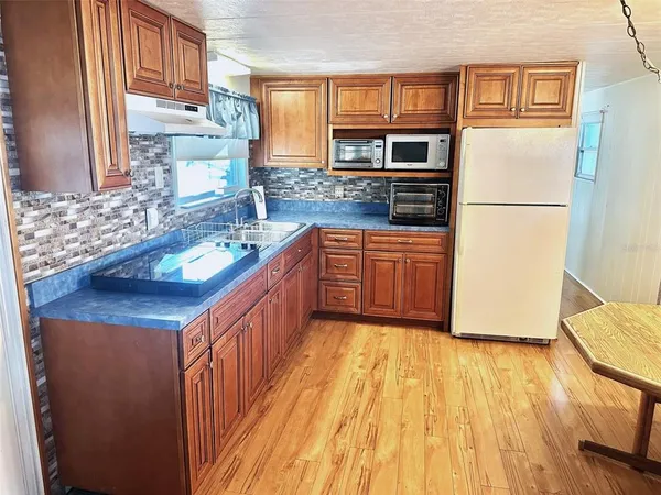 a kitchen with stainless steel appliances granite countertop a refrigerator a stove top oven a sink and dishwasher