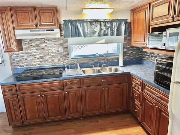 a kitchen with stainless steel appliances granite countertop wooden cabinets and a counter top space