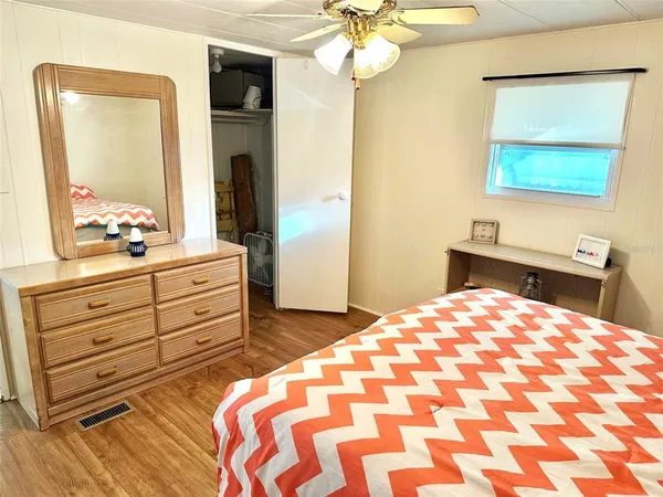 a bedroom with a bed and a mirror on dresser