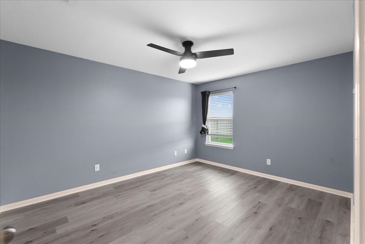 5727 Treasure Cove Road Cove, TX 77523 - Photo 12 of 20 an empty room with wooden floor and windows