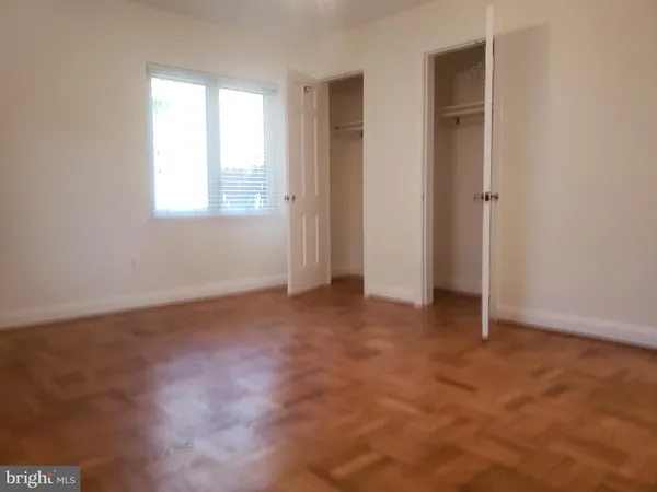 an empty room with windows and closet