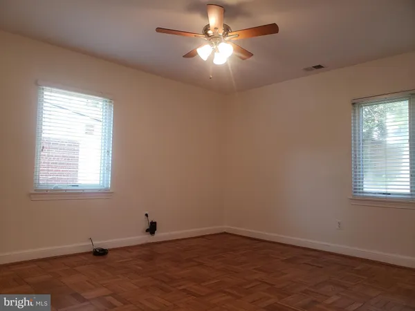 an empty room with a window and a fan