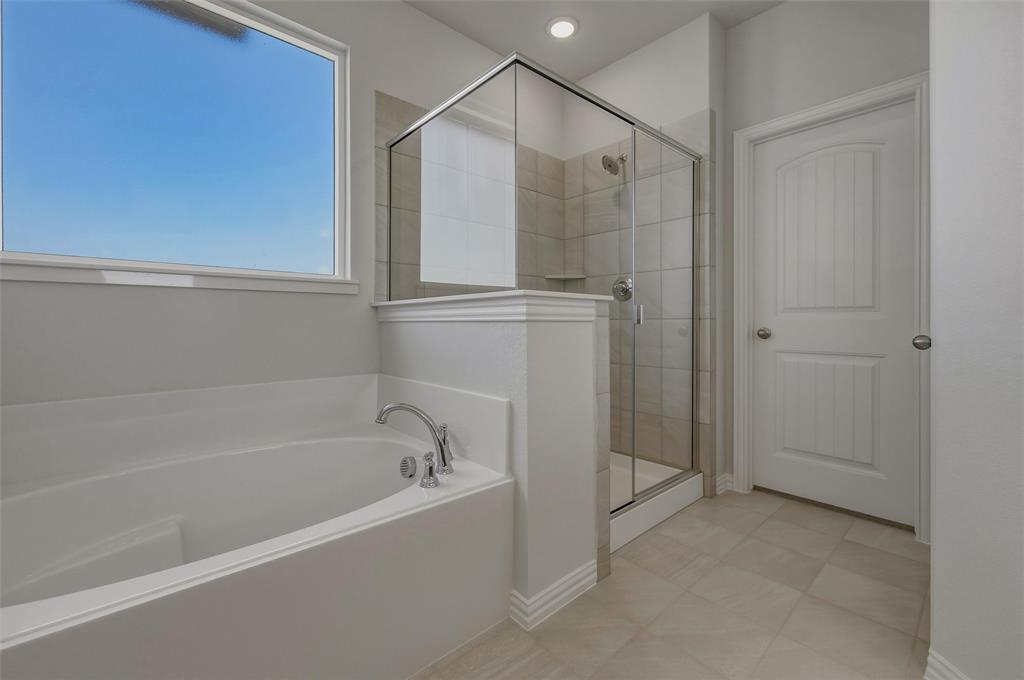 1337 Frio Drive Springtown, TX 76082 - Photo 29 of 40 Soaking tub with chrome fixtures, glass-enclosed shower with tiled surround, large window, and tiled flooring