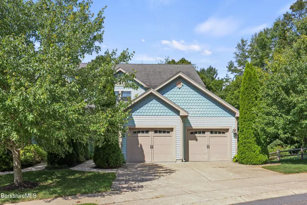 a view of a house with a yard and large tree