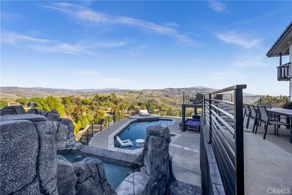 a view of a terrace with furniture and a garden