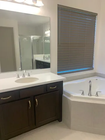 a bathroom with a double vanity sink mirror and shower