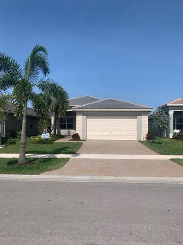 a front view of a house with a yard and a garage