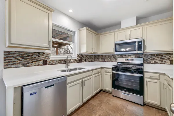 a kitchen with stainless steel appliances granite countertop a sink and a stove