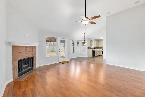 a view of empty room with wooden floor and fireplace