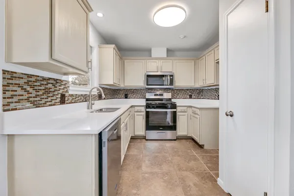 a kitchen with stainless steel appliances granite countertop a sink and cabinets with wooden floor