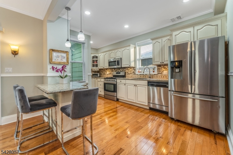 119 Edgewood Road Linden, NJ 07036 - Photo 8 of 31 a kitchen with stainless steel appliances granite countertop a refrigerator a stove top oven a sink dishwasher and white cabinets with wooden floor