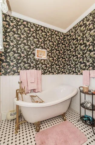 a bedroom with a bed a chair and a flat screen tv