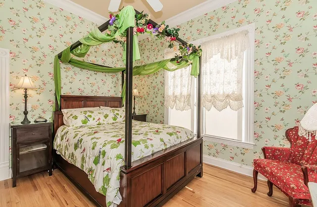 a bedroom with a bed dresser and a chandelier