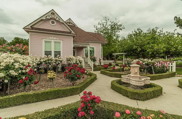 a front view of a house with a yard and fountain