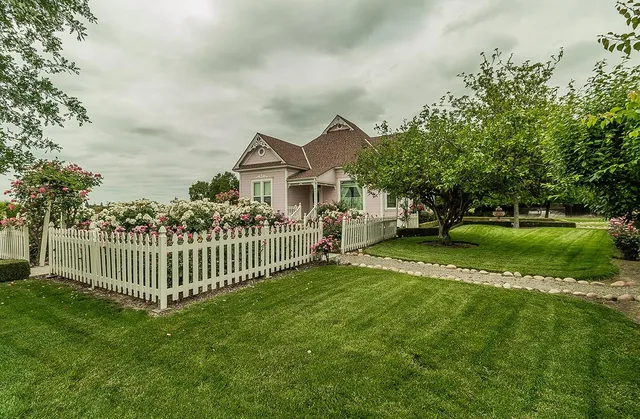 a front view of a house with a garden and yard